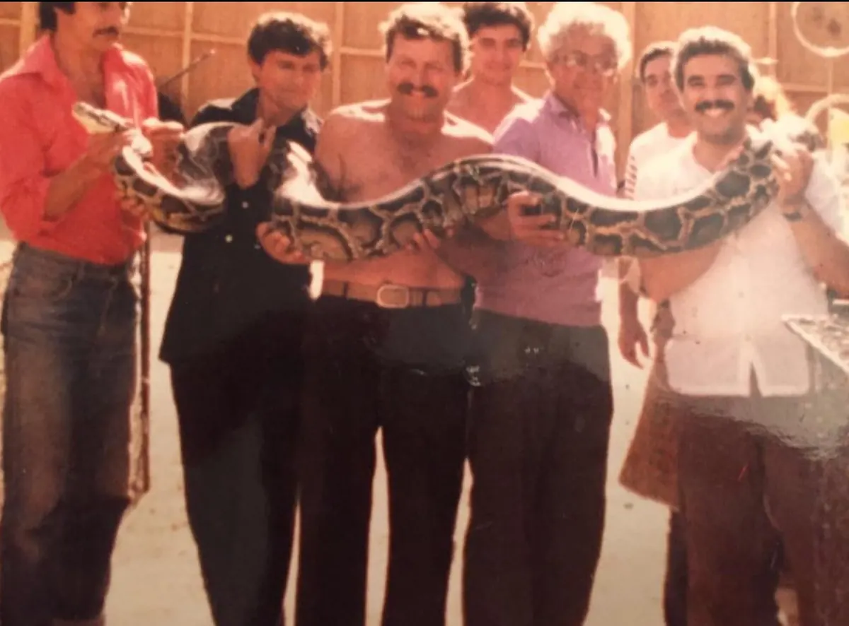 Dr. Faisal with colleagues and a large python in the early 1980s